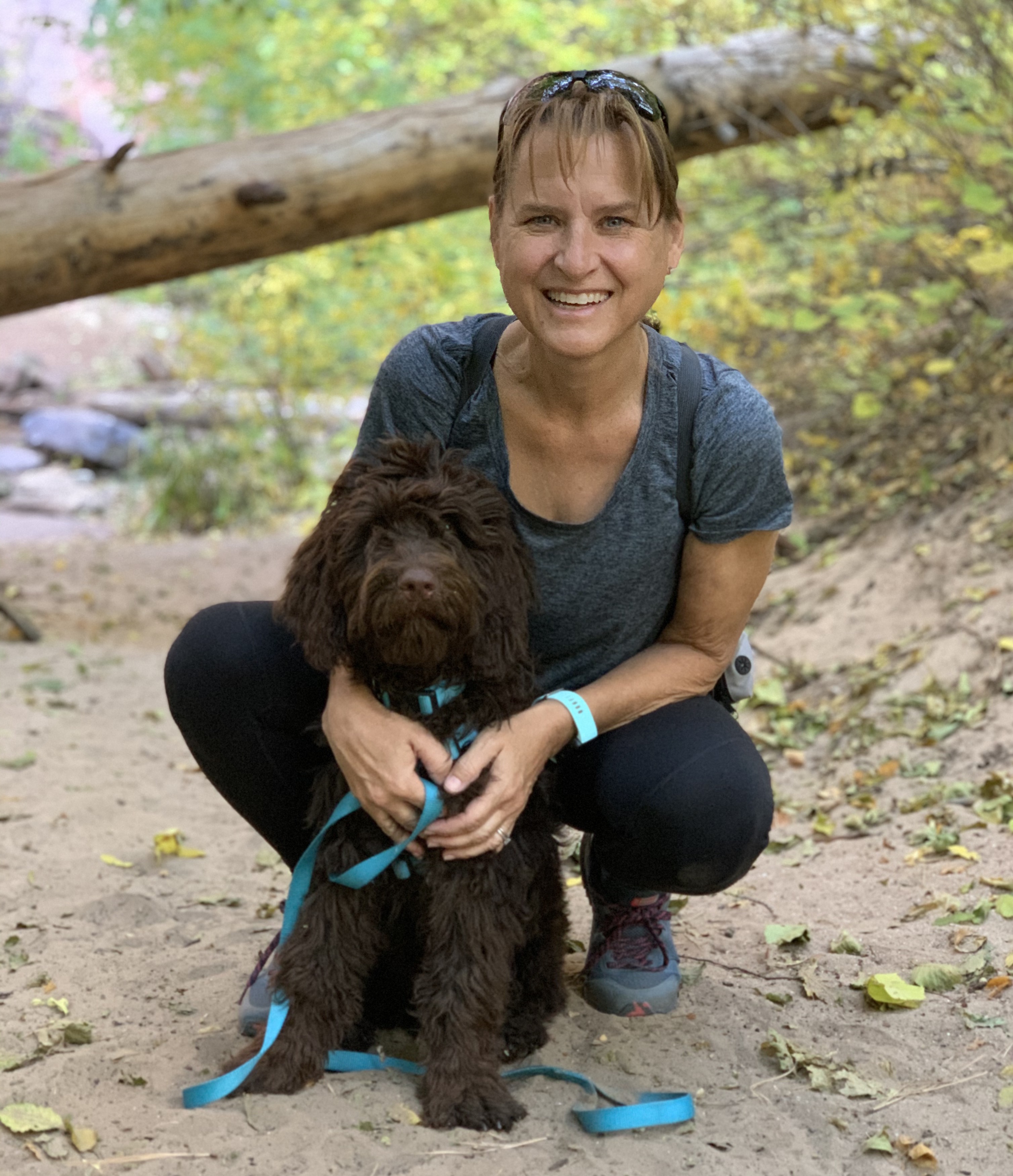 Stephanie kneeling down with her dog by her side